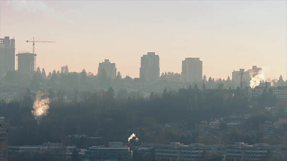 Smoke Rises From Chimneys In Afternoon City