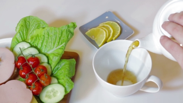 Teapot Pouring Tea Into Cup