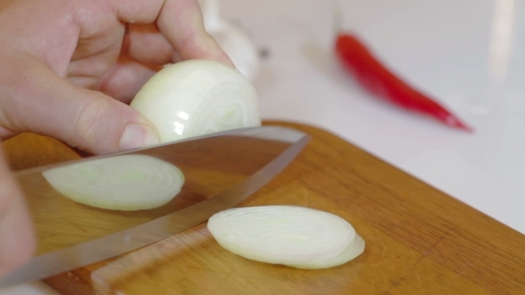 Man Cutting Up An Onion With a Knife