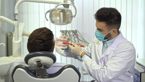 Dentist Show His Patient How To Brush Teeth