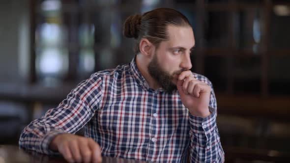 Thoughtful Handsome Caucasian Man Sitting at Bar Counter Waiting Looking Around