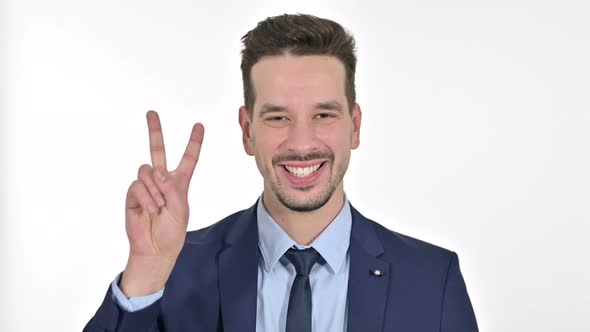 Portrait of Successful Young Businessman Showing Victory Sign , White Background