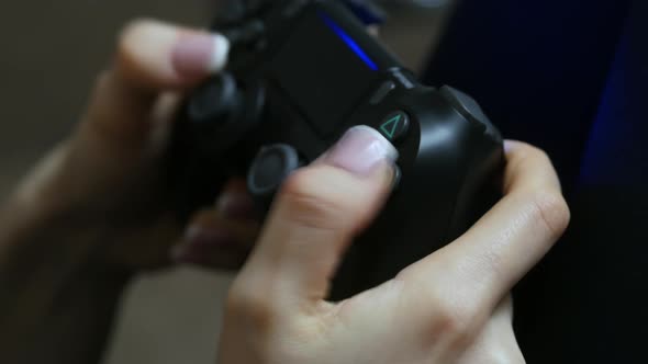 Close-up of a Girl's Hands Playing a Video Game on a Gamepad at Home