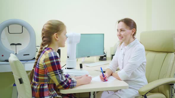 Doctor Interviews Little Girl Before Being Examined in Ophthalmologist's Office