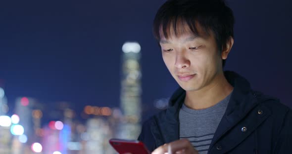 Man use of smart phone in Hong Kong at night