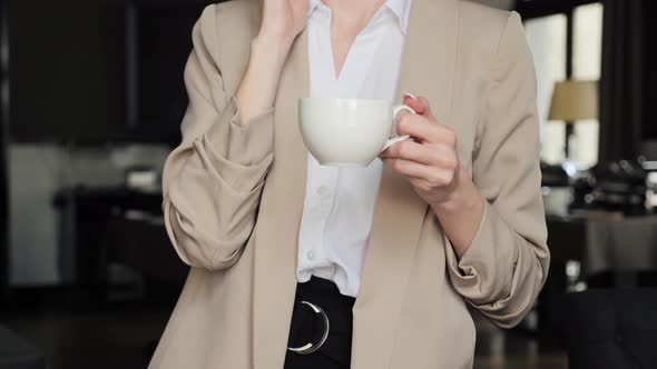 Business Woman Calling By Mobile Phone While Drinking Coffee in Hotel Lounge
