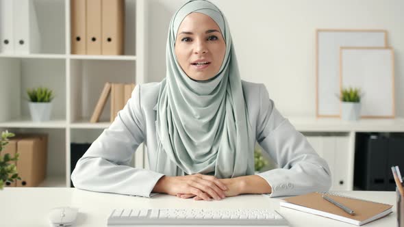 Independent Muslim Lady Wearing Hijab Discussing Business Ideas During Video Call From Office