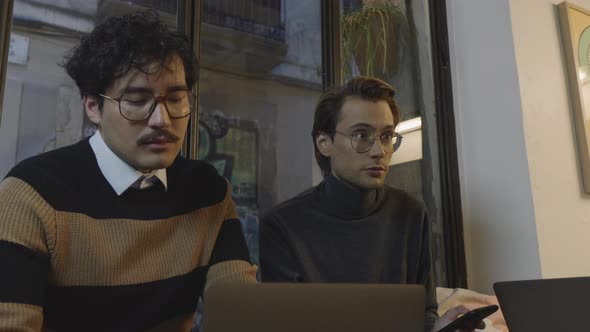 Business Men Having Conversation in Cafe. Businessman Working on Laptop Indoors