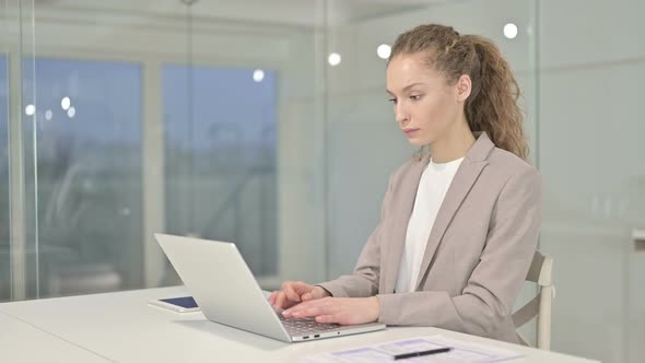 Ambitious Young Businesswoman Working on Laptop in Office
