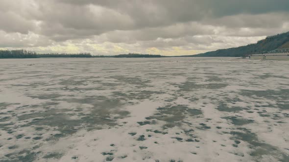 Motion Above Brown Dirty Snow and Ice on River Water Surface