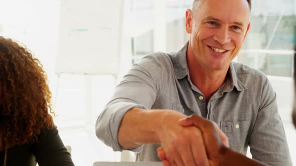 Business colleagues shaking hands in the office