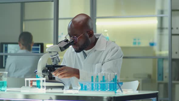 African American Scientist Working with Microscope in Lab