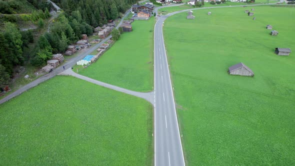 Empty Asphalt Road in Austria Between Green Fields in the Alps Aerial View