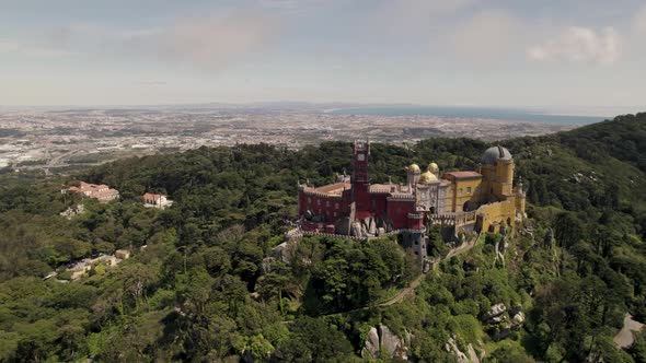 Fairy tale hilltop castle, colourful Pena Palace. Natural Park Sintra, Portugal. Scenic aerial view