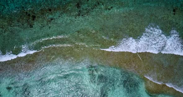 Beautiful fly over island view of a white paradise beach and aqua blue water background 