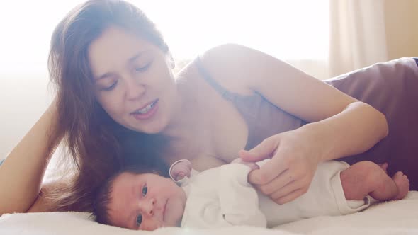 Newborn baby boy and his mother at home. Close-up portrait of the infant