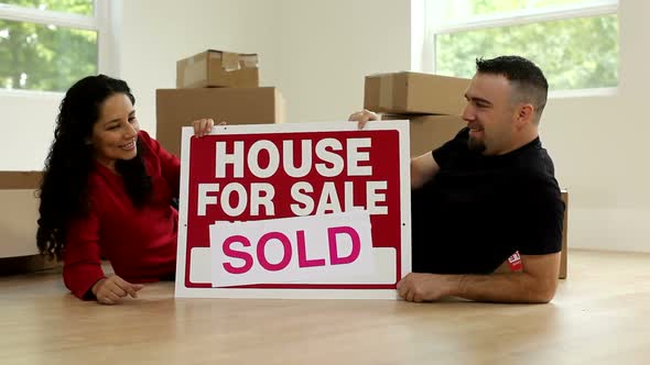 Couple in new home with sign