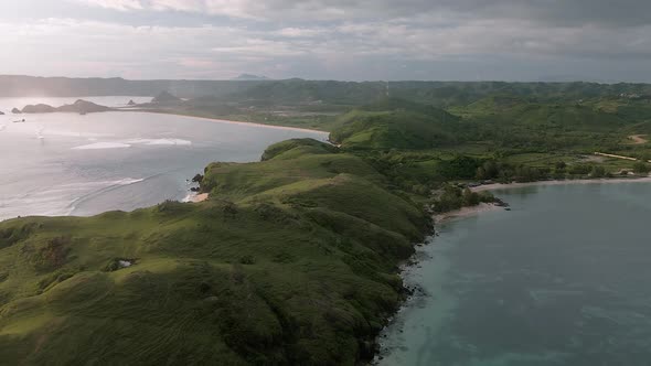 Aerial orbiting shot over Lombok Island with famous Bukit Merese Hills and sandy beaches with crashi