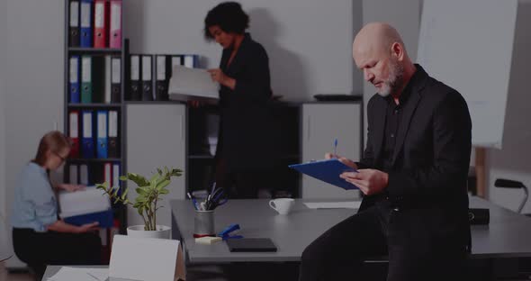 Businessman Writing on Document in Office