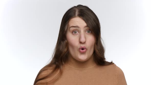 Studio Portrait of Amazed Woman Opens Widely Eyes and Mouth