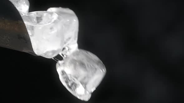 Ice Cubes are Falling From Bartender's Ice Scoop in Slow Motion on the Black Background Full Prores