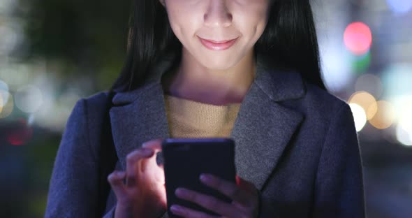Young Woman use of mobile phone in Hong Kong at night