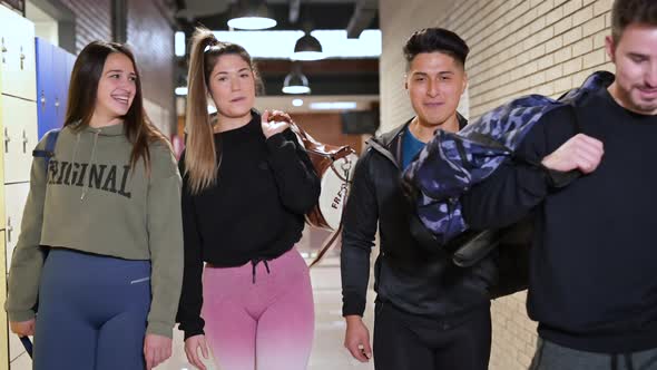 Happy Group of Friends in Sportswear Walking in Gym Corridor