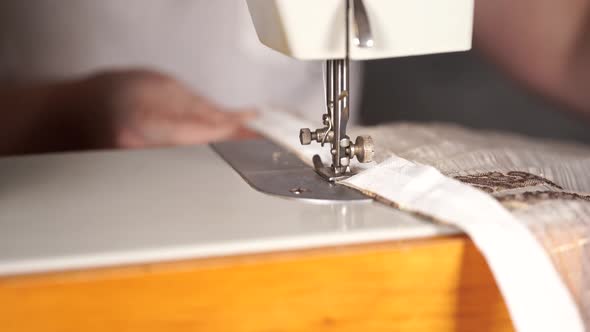 Close Up of Sewing Machine with Women's Hands on Table