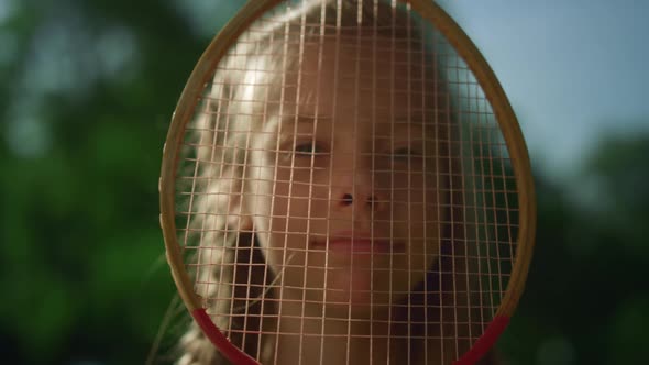 Joyful Little Kid Making Funny Face with Badminton Racket