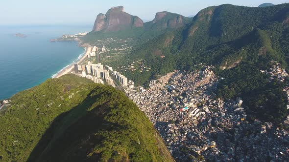 Aerial Drone Shot Following a Mountain Ridge Revealing the Ocean and Condos in Rio De Janeiro Brazil