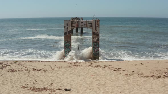 Aerial View of old broken pier made of cement in the middle of the ocean near Santa Cruz California.