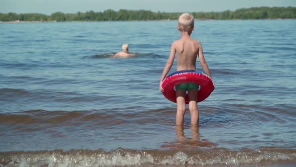 A hot summer day is a great option for a family holiday on the lake. A little boy watches