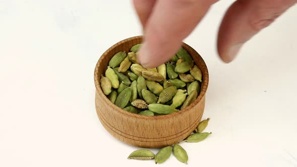 Chef Taking Dry Cardamom Seeds From Wooden Spice Jar for Preparation Food