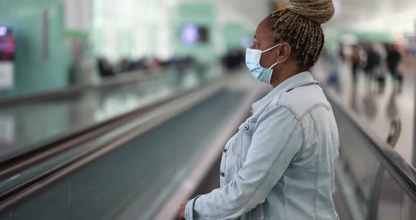 Mature african woman wearing safety face mask inside international airport