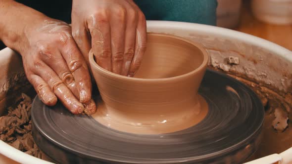 Man's Hands Sculpting a Pot Out From the Clay