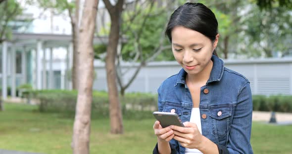 Woman using cellphone at outdoor park 