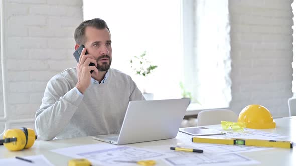 Young Architect Talking on Smartphone in Office 