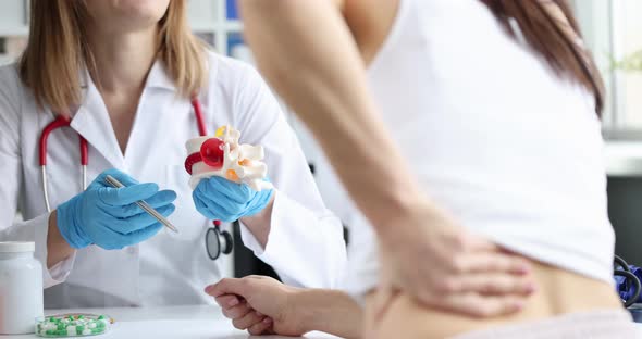 Woman with Back Pain at Doctor Appointment Closeup