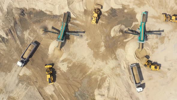 Aerial view, machinery working at clay quarry, heavy loaders, large trucks, bulldozers, excavators,