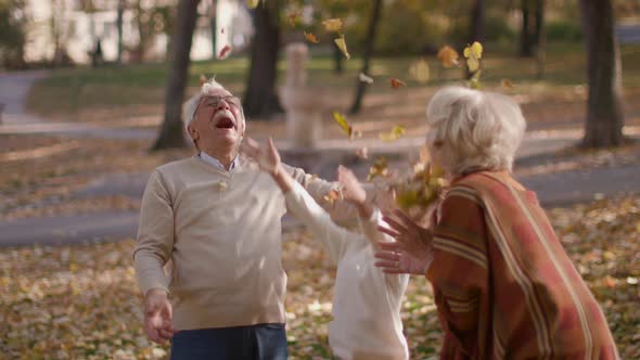 Grandparents enjoying good time with their cute little granddaughter in the autumn park