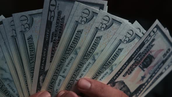 Closeup of Hundreddollar Bills in the Hands of a Banker