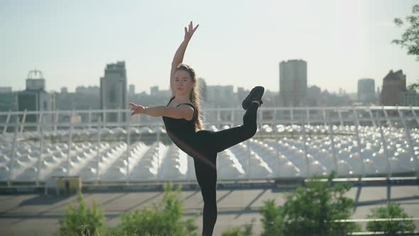 Camera Approaches To Flexible Ballet Dancer Standing on One Leg and Looking at Camera. Slim