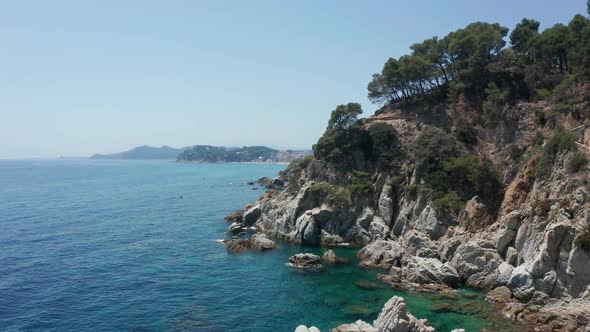 Aerial View of Rocky Coast and Blue Sea Water