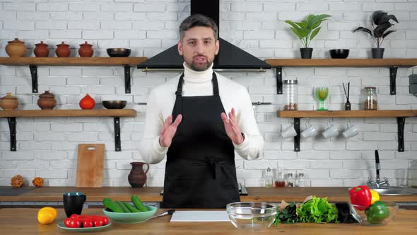 Man chef in apron teaches housewife online video culinary webinar in kitchen