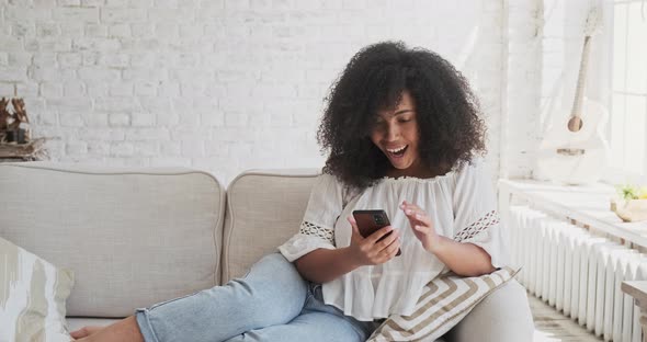 Celebrating Achievement or Wining Betting Victory Smiling Female Enjoying Using Smartphone