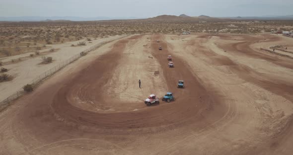 Dirt track UTV racing around corner in Mojave Desert, AERIAL