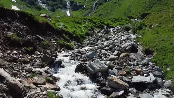 Flying low over a water stream in Austria with lot of rocks.