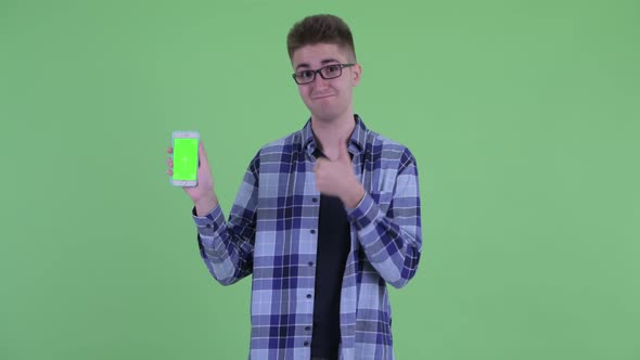 Happy Young Hipster Man Showing Phone and Giving Thumbs Up