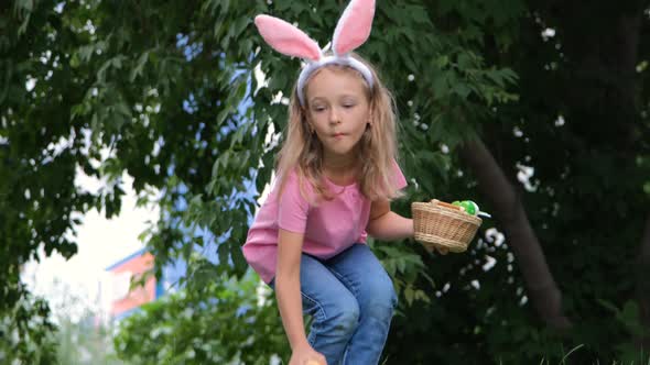 Little Girl Gathering Easter Eggs in Spring Park