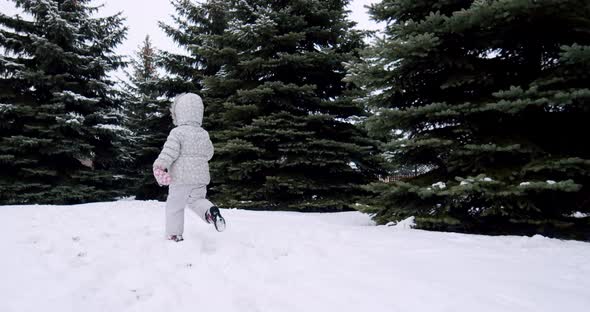 Cheerful children play snowballs on the street